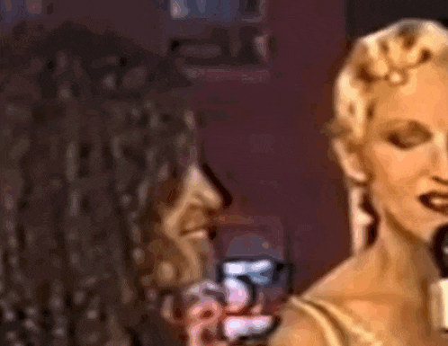 two women are standing next to each other in a dark room .