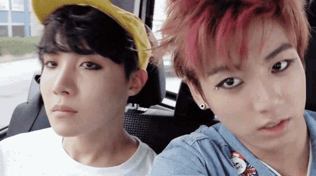 two young men are sitting next to each other in a car