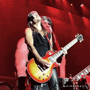 a man playing a guitar with a tag that says ' slash ' on it