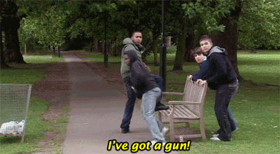 a group of young men standing around a park bench with the caption i 've got a gun ..
