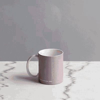 a person is scooping ice cream into a pink mug