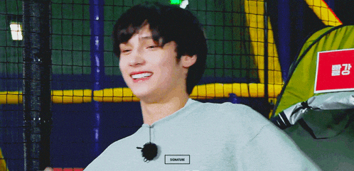 a young man wearing a gray shirt with the word sonam on the front