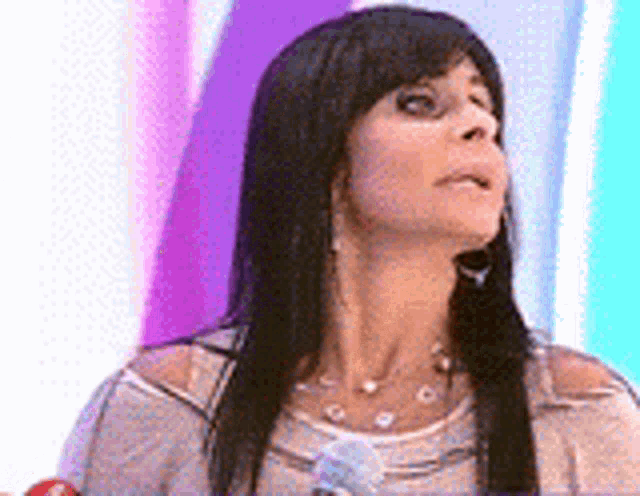 a woman with long black hair is wearing a necklace