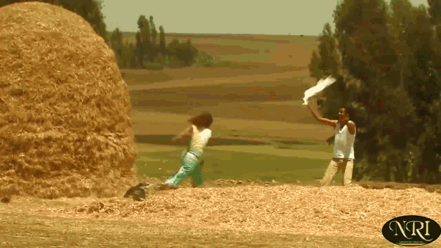 a man and a woman standing in a field with nri written on the bottom