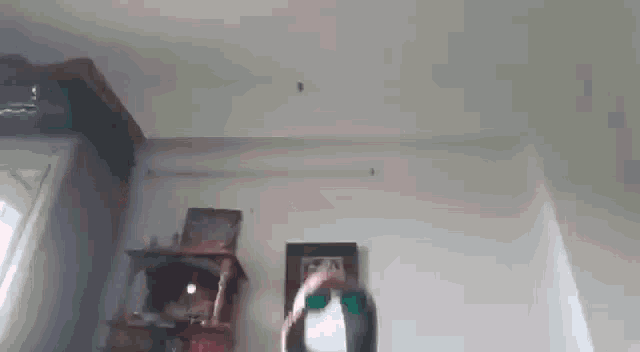 a person is standing in a room with a picture on the wall and a clock on the wall .