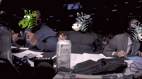 a can of monster energy sits on a table in front of a group of people with zebra masks on their faces