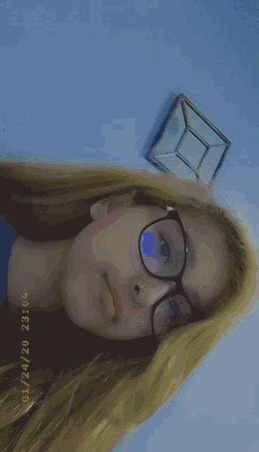 a girl wearing glasses is taking a picture on 01/24/20