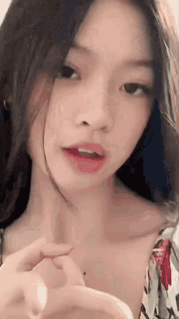 a close up of a woman 's face with her hand on her neck