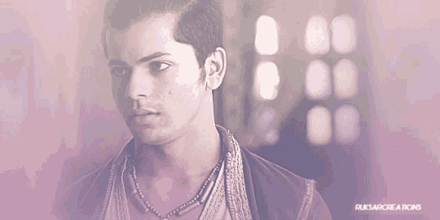 a man with a necklace around his neck is looking down with a purple background that says fuksarcreations