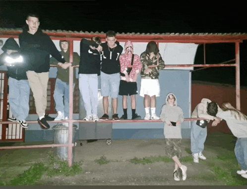 a group of young people are posing for a picture with one wearing a hoodie that says supreme