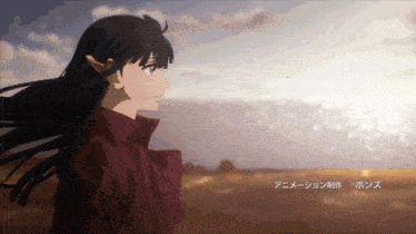 a girl with long black hair is looking at the ocean