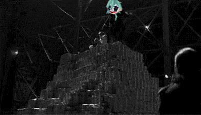 a cartoon character with green hair and glasses is standing next to a pile of trash .