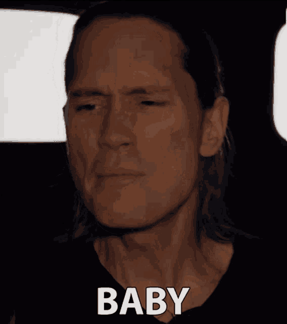 a close up of a man 's face with the word baby written below it