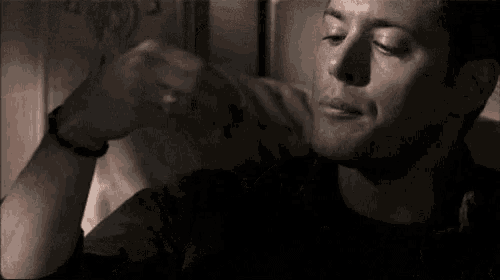 a man is sitting on a bed with his eyes closed and making a funny face .