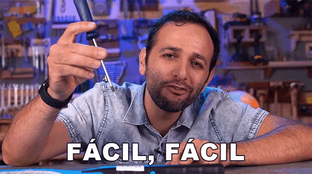 a man is holding a soldering iron with the words " facil " written on the bottom