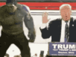 a man in a suit and tie is standing next to a podium that says trump
