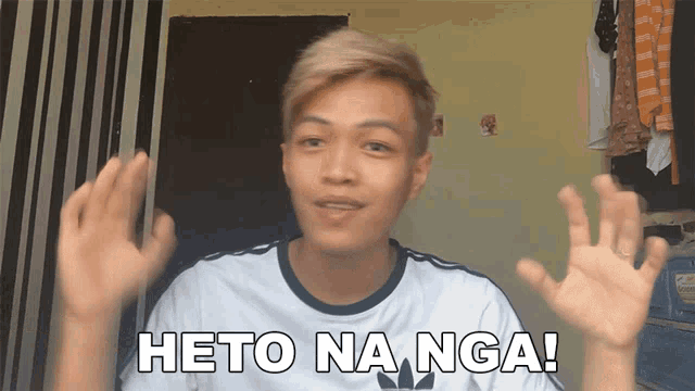 a young man wearing a white shirt with the word heto on it