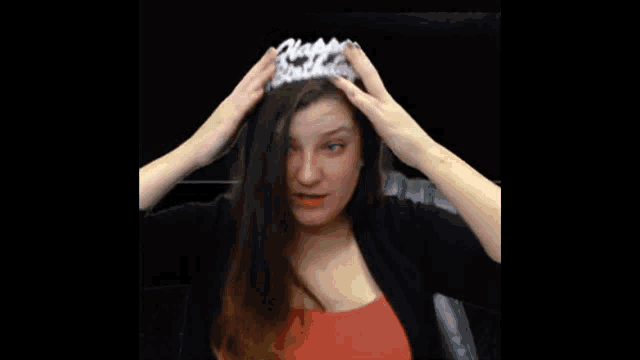 a woman wears a tiara that says happy birthday