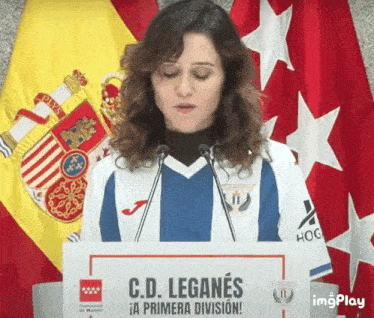 a woman stands at a podium that says c.d. leganes