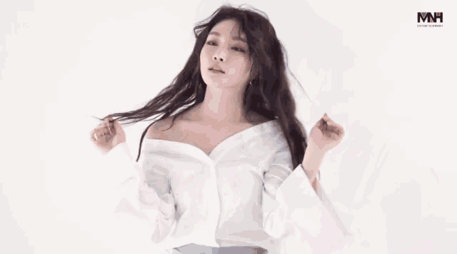a woman wearing a white shirt with mh entertainment written in the corner