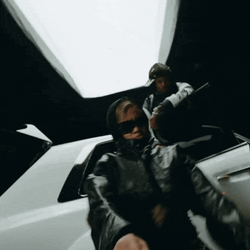 a man wearing sunglasses is sitting in a car with another man