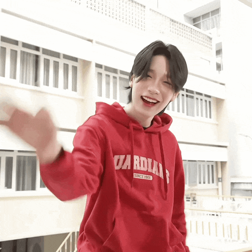 a young man wearing a red hoodie that says cardial since 1997