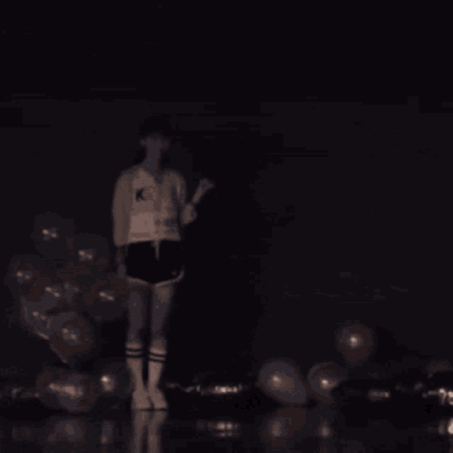 a girl is standing in front of balloons with the words vote for me written on the wall behind her