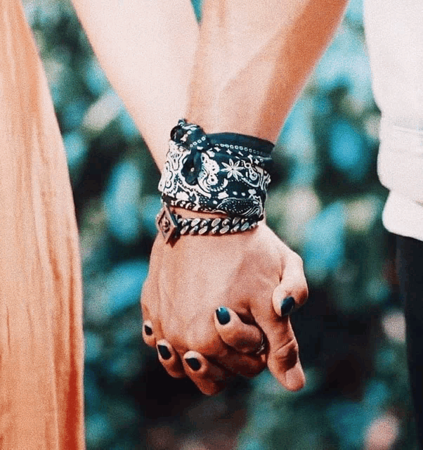 a man and a woman holding hands with bracelets on