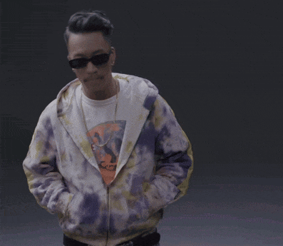 a man wearing sunglasses and a purple tie dye jacket