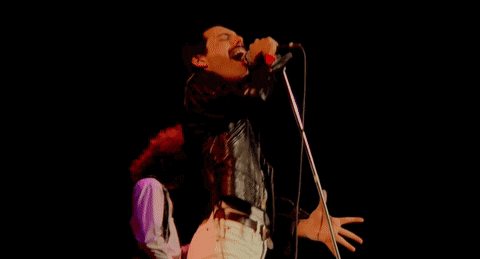 a man in a leather jacket is playing a guitar on stage .