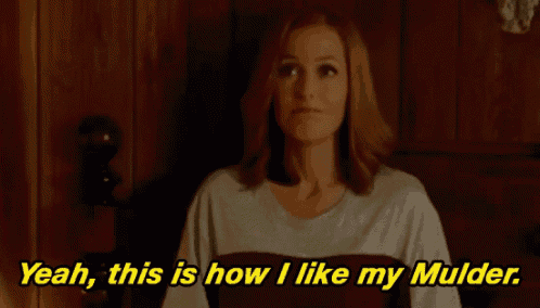 a woman is sitting on a bed and says yeah this is how i like my mulder .