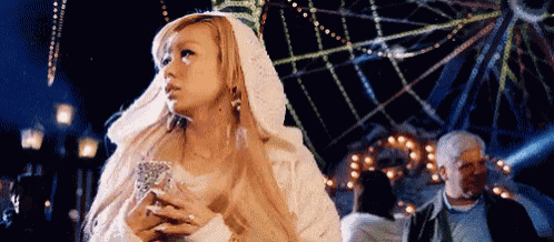 a woman in a white robe is holding a tarot card