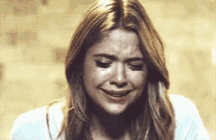 a close up of a woman crying with her eyes closed and her mouth open .