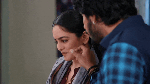 a man is touching a woman 's face with his finger .