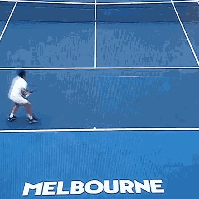 a tennis player is falling on a court with the word melbourne on it