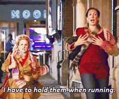 two women are running down a street with the words i have to hold them when running
