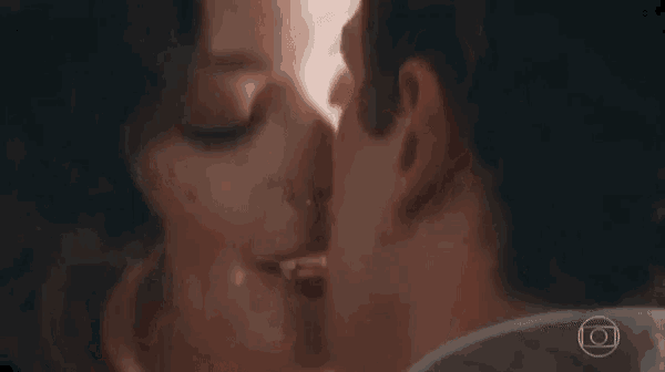 a man and a woman are kissing each other in a dark room .