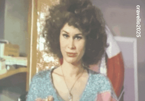 a woman with curly hair is standing in front of a red white and blue flag with the year 2020 on the bottom