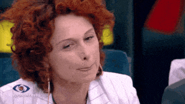 a close up of a woman 's face with the hashtag grandefratello on the bottom right