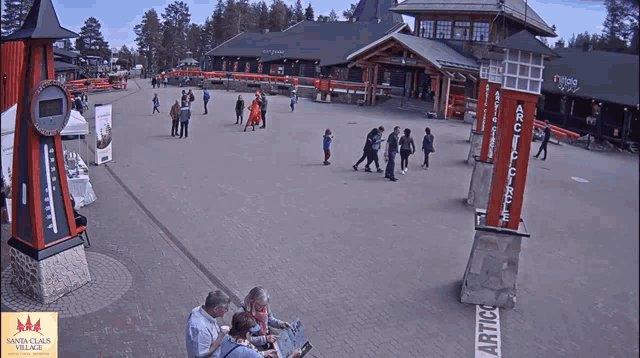 a group of people are standing in front of a building that says arctic village