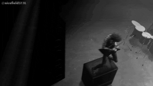 a black and white photo of a person playing a guitar with the words nicefieldsfm on the bottom right