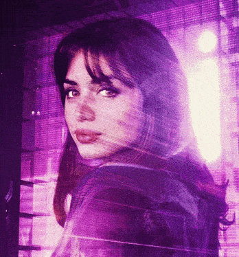 a close up of a woman 's face with a purple background behind her