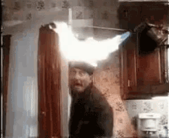 a man is standing in a kitchen with smoke coming out of the ceiling behind him