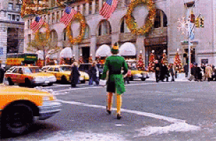 a man dressed as an elf is crossing a busy street .