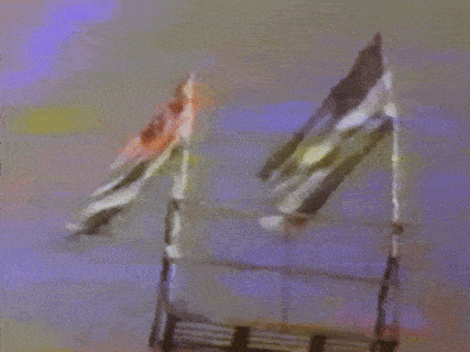 two flags are hanging from a ladder in a blurry photo