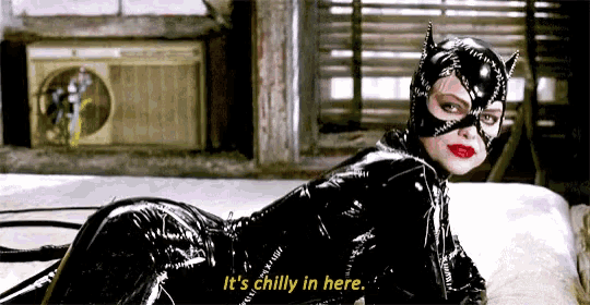 a woman in a catwoman costume is laying on a bed and says it 's chilly in here .