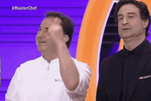 two men are standing next to each other on a stage and one of them is giving a fist bump