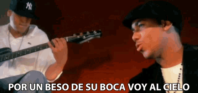 a man playing a guitar next to another man with the words por un beso de su boca voy al cielo on the bottom