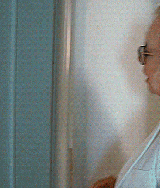 a person standing in a doorway with a white curtain behind them