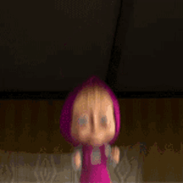 a cartoon character with pink hair is laying on a couch .